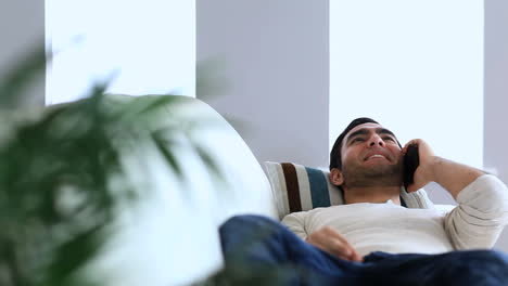 man having a phone conversation on the couch