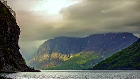 grey clouds flying over mountains and norwegian fjord - time lapse shot