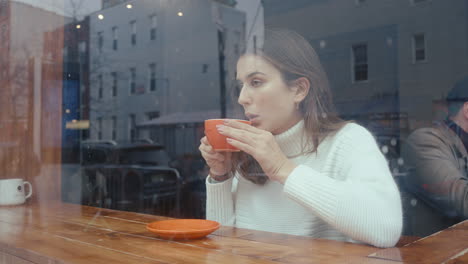 mujer bebiendo café en una cafetería