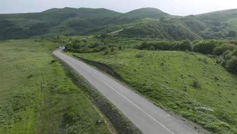 bird's eye shot of a road and a valley during sunny day in kojori, georgia