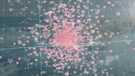 animación de corazones rosados flotando sobre la cuadrícula y el paisaje marítimo.