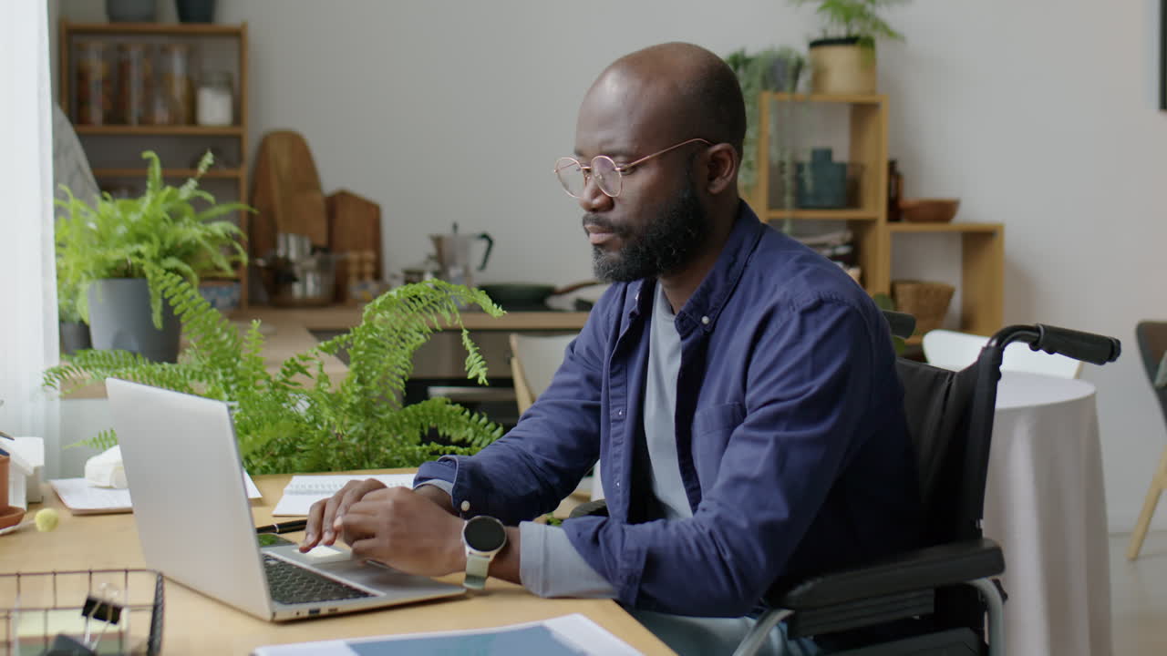 Black Man in Wheelchair Working Remotely from Home
