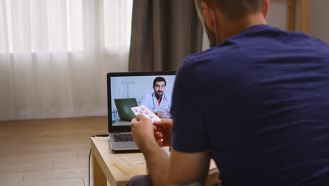 hombre escuchando a su médico en una llamada de video