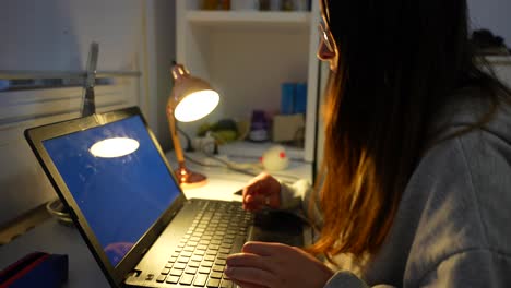 la chica se pone en el portátil tarde en la noche y se registra en la computadora ingresando la contraseña.