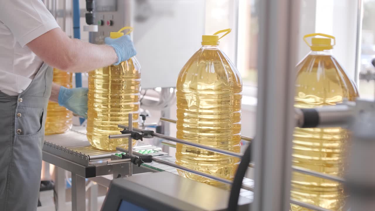 생산 라인에서 움직이는 병에 있는 해바라기 기름. 병에 담긴 해바라지 기름을 병에 담는 라인. 식물성 기름 생산 공장. 첨단 기술. 산업적 배경