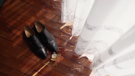 Close-up-of-wedding-accessories-on-wooden-floor-in-a-vintage-room-setting