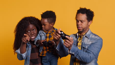 Cheerful-african-american-dad-playing-video-games-with-his-son-on-console