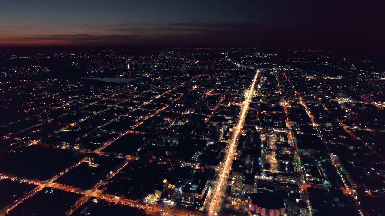 Aerial drone view of Chisinau at sunset, Moldova. View of city centre with multiple buildings, roads with traffic, illumination