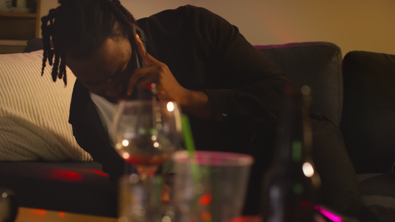 집 파티에서 알코올을 마신 후 소파에서 깨어난 남자가 숙취로 고통 받고 휴대 전화로 이야기합니다.