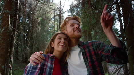 couple hugging in fairytale forest. smiling tourists taking break during hike