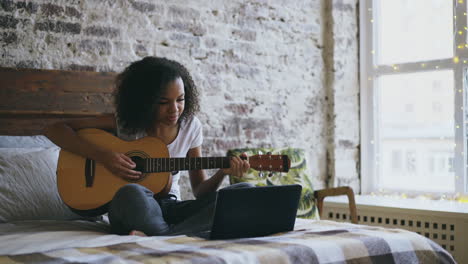 young woman learning guitar online