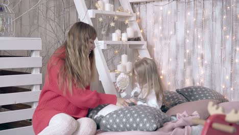 beautiful blond mother plays with cute little daughter