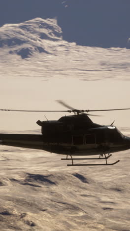 helicopter flying over snowy mountains