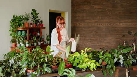 mujer regando plantas en una tienda de plantas