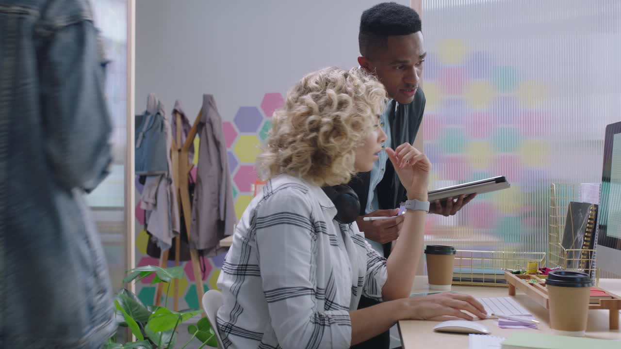 creative business people meeting team leader man sharing ideas pointing at screen discussing project training colleague career development enjoying collaborating in colorful trendy office