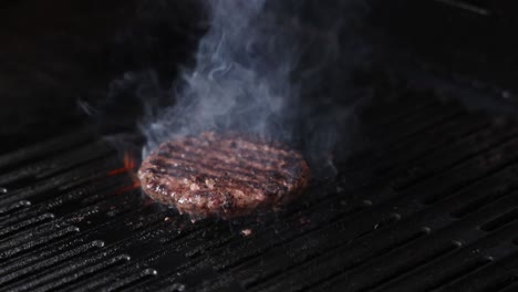 la hamburguesa a la parrilla se enciende y fuma.