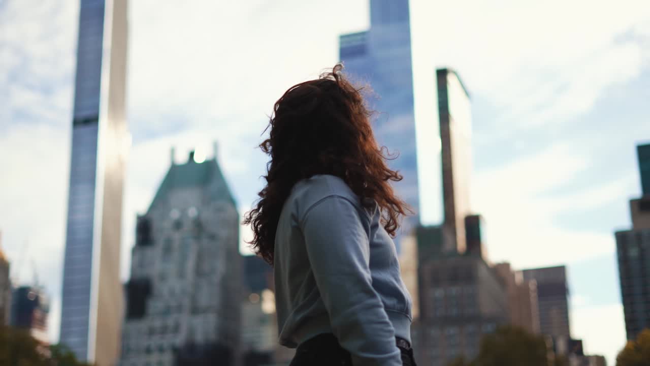 joven mujer morena mirando el horizonte de la ciudad de nueva york en cámara lenta