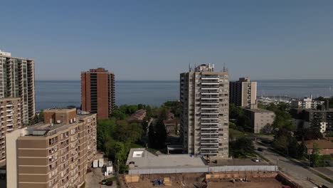 Side-movement-shot-of-buildings-by-a-lake-in-Oakville,-Ontario,-Canada