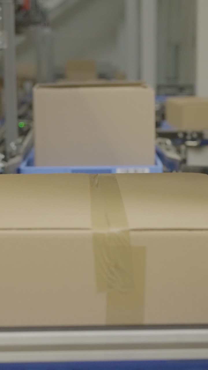 Boxes on conveyor belt in a busy warehouse, showcasing logistics