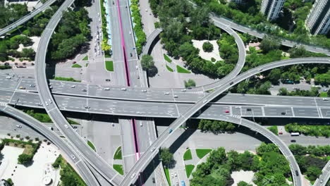 aerial view of circular viaduct road multilevel interchange overpass or highway intersection with busy urban traffic speeding on the elevated road