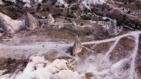 Aerial-flying-over-Kizilcukur-Valley-showing-2-horses-galloping-on-a-dirt-road,-Cappadocia