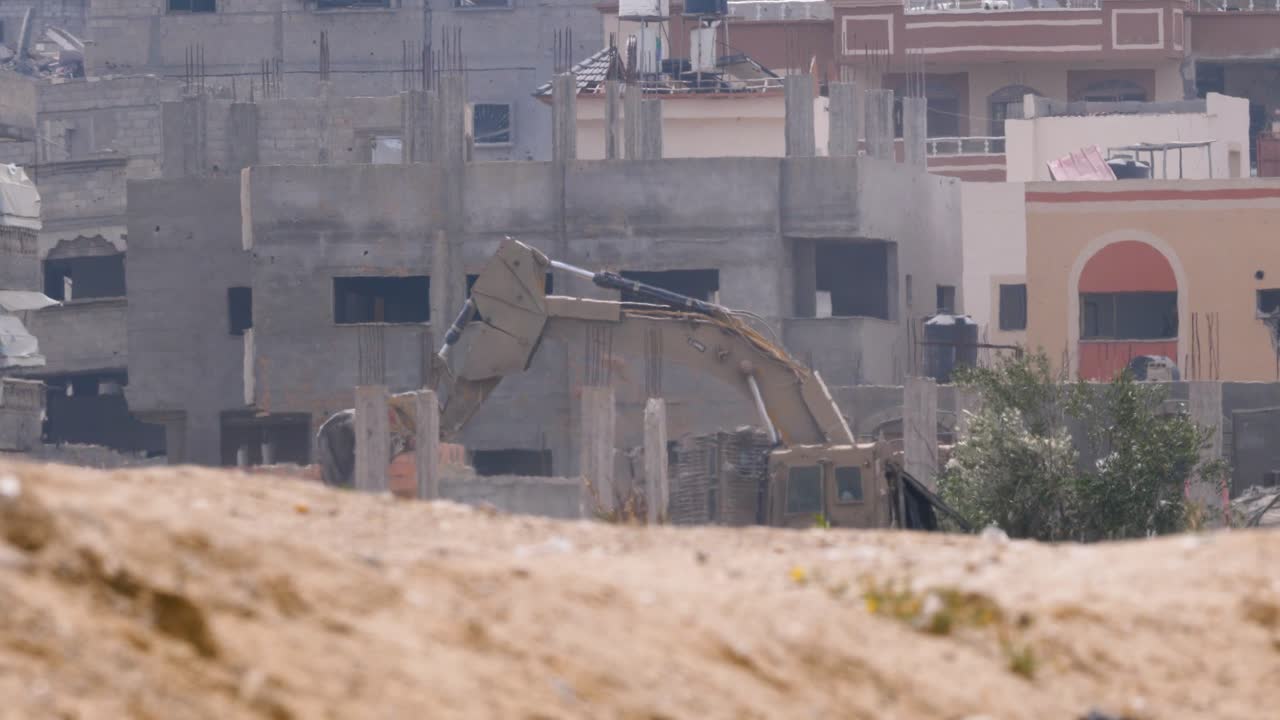 Escavatore che rimuove macerie in una città rurale di Israele durante il conflitto della guerra Israele-Hamas.