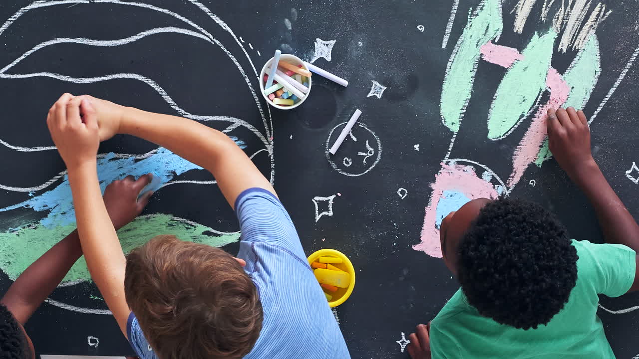 Children Drawing Space Themes on a Blackboard