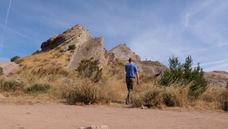 Man-hiking-at-Vasquez-Rocks-in-the-United-States-southwest,-walks-away