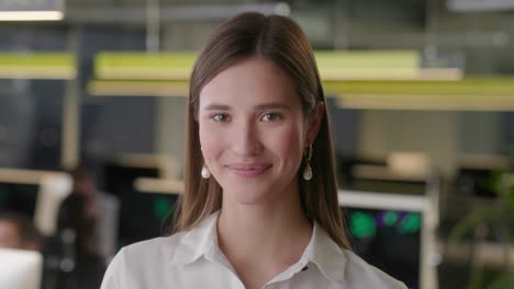 retrato de una hermosa mujer joven con camisa blanca mirando hacia la cámara y sonriendo encantadoramente. mujer exitosa trabajando en una oficina de espacio abierto