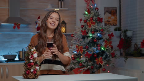 Young-woman-talking-on-video-call-holding-glass-of-wine