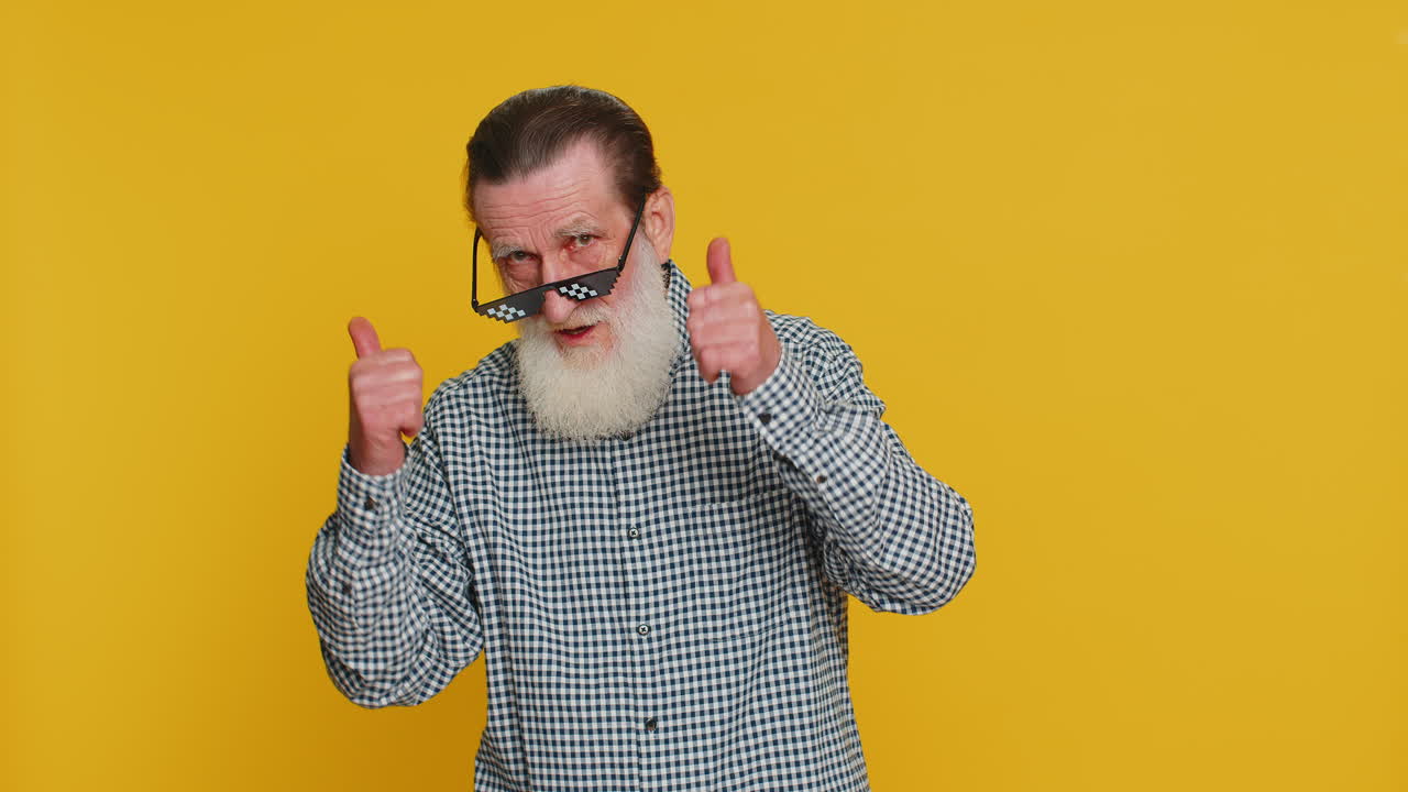 흑색 선글라스를 입고, 매력적인 미소를 짓고, 성공을 축하하는 세련된 노인