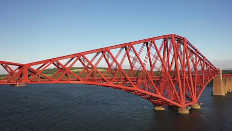 luchthoek van een trein die langs de vierde spoorwegbrug in zuid-queensferry reist op een zonnige zomeravond in schotland