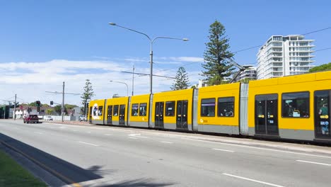 yellow tram travels through city street scene