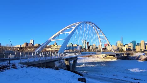 stunning twilight loop time lapse sunset post modern walter dale bridge winter sunny frozen north saskatchewan river family couple out for a walk on a clear blue skies sunshine lovely city skyline 2-4