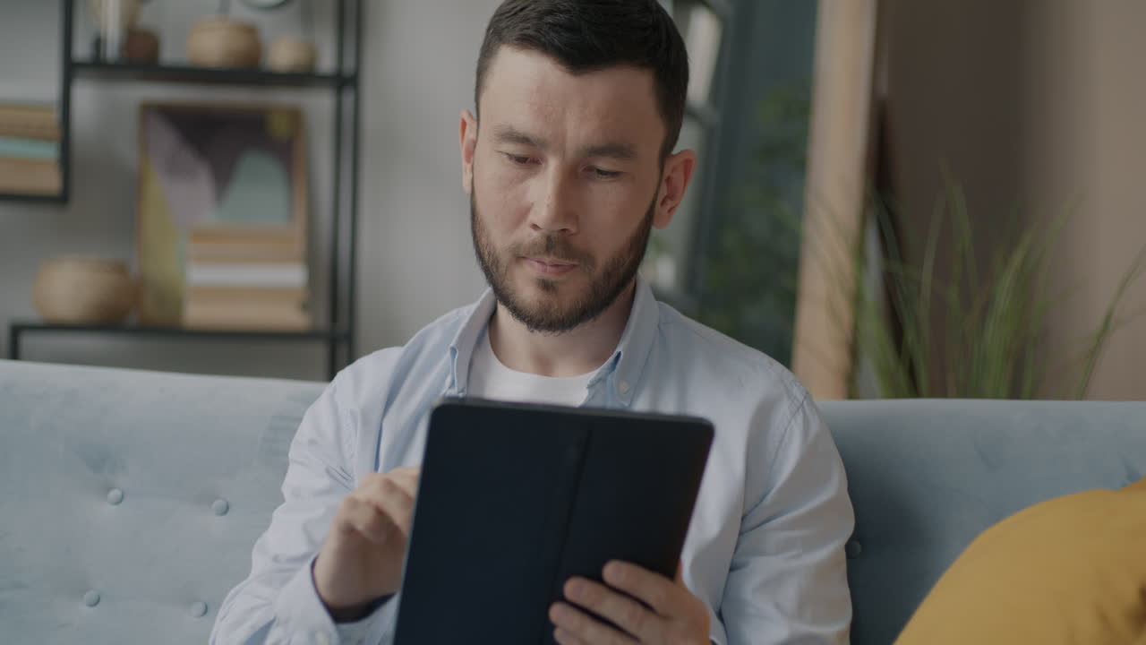 집에서 태블릿을 사용하는 남자