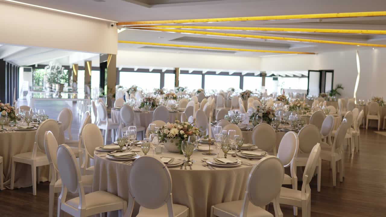 Elegante salón de banquetes preparado con mesas y decoraciones de boda