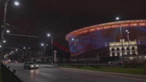 city street at night with illuminated stadium