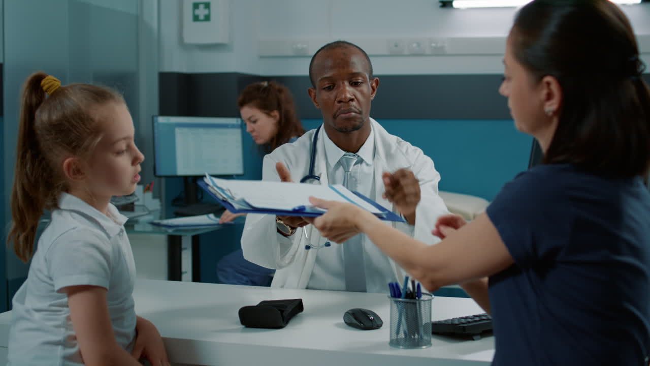 Doctor examining child patient with parent in clinic