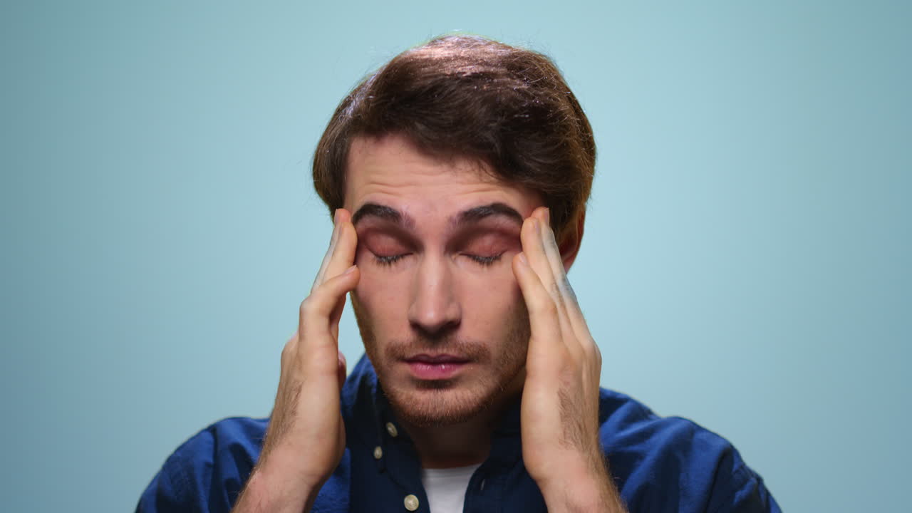 retrato de un hombre cansado con dolor de cabeza. rostro de hombre estresado sobre un fondo azul