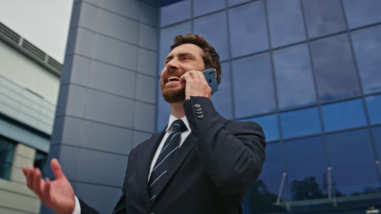 Smiling manager talking mobile phone outside office closeup. Confident man