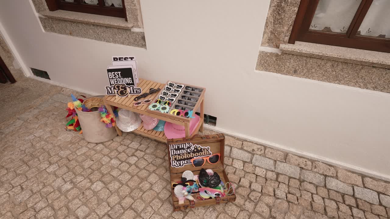 Photo booth props with fun sunglasses and signs arranged on a rustic outdoor display