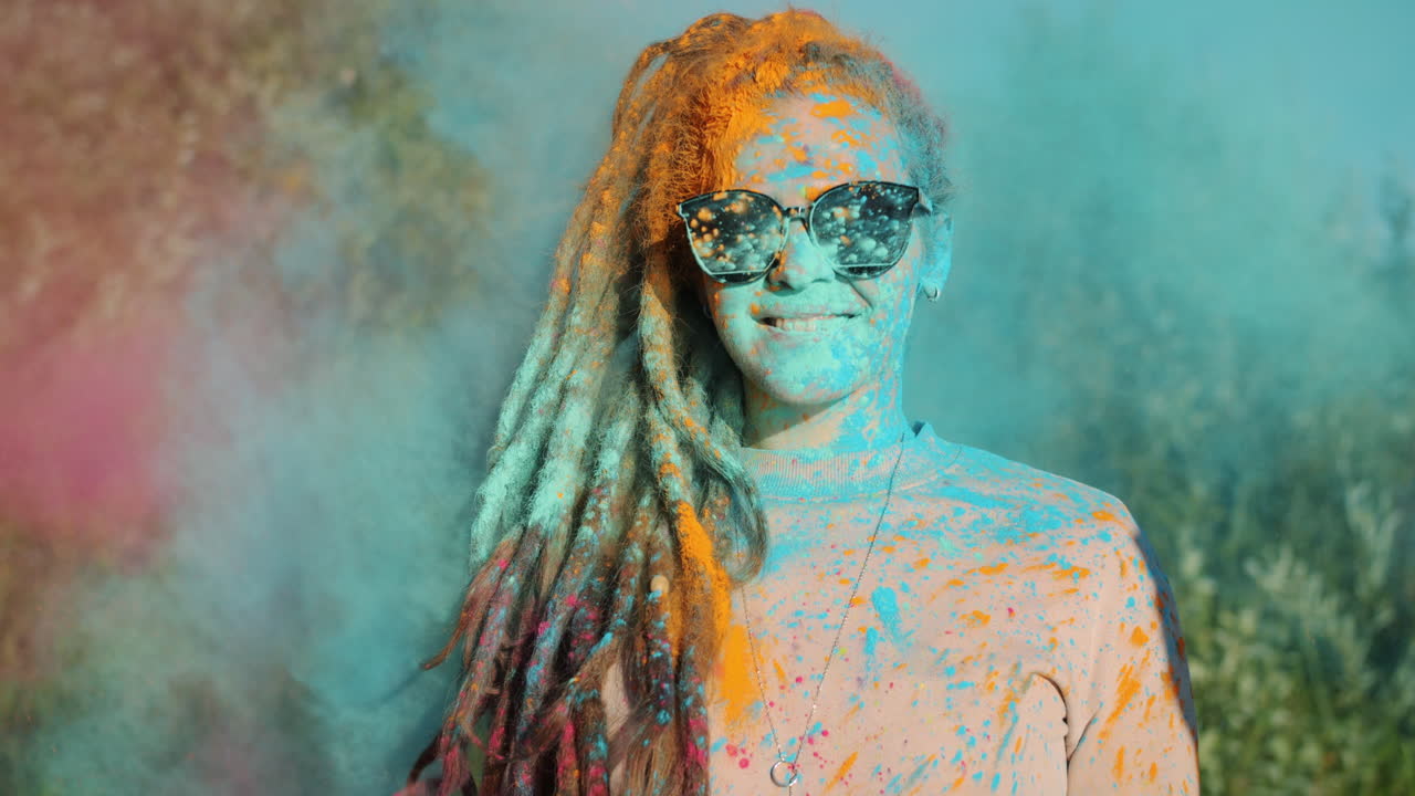 Donna che celebra l'Holi con polvere colorata