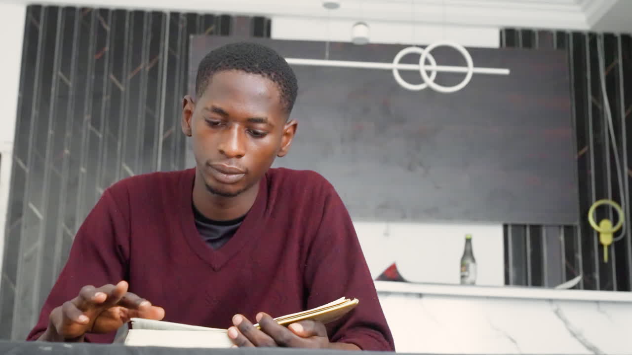 Black painting, man calculating with beads. Seated at marble counter with notebook, deliberate finger movements over beads and notes, modern interior with dark painted backdrop and circular wall