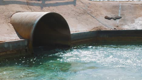 Clean-Saltwater-Flowing-Out-Of-The-Tunnel-Towards-The-Salt-Flats-In-Kralendijk,-Bonaire