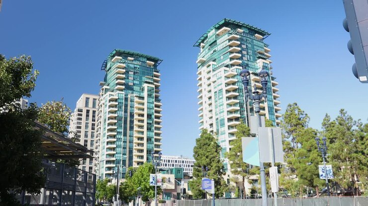 Vídeo 4K das Torres Gêmeas entre árvores verdes sob céus azuis no centro de San Diego em um dia quente de setembro de 2023