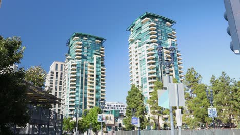 video de 4k de las torres gemelas en medio de árboles verdes bajo un cielo azul en el centro de san diego en un cálido día de septiembre de 2023