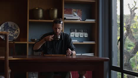 man engaged in a traditional tea ceremony, drinking tea