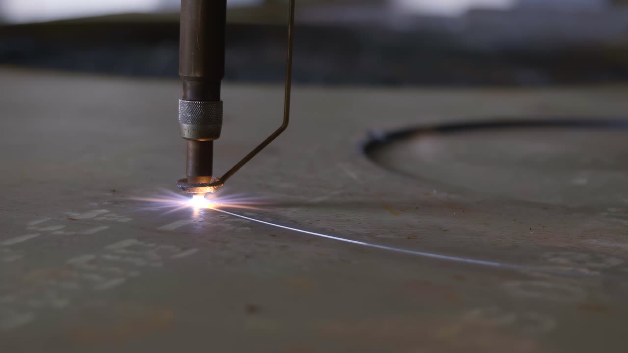 Filmato ravvicinato di una taglierina al plasma che taglia metallo spesso, producendo scintille intense e un flusso di acciaio fuso. Scena industriale ad alta energia con luce d'arco brillante e materiale incandescente.