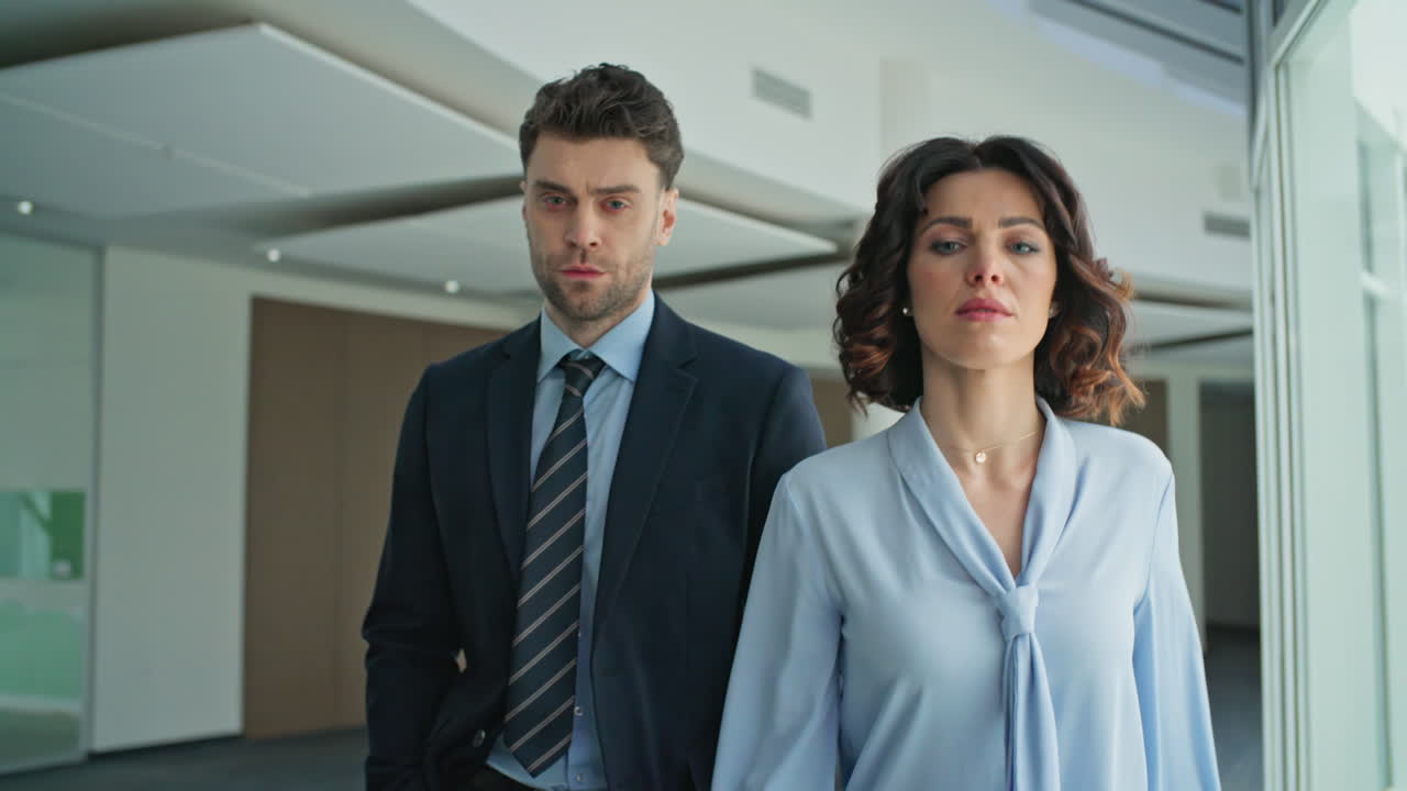 Serious businesspeople walking office hallway closeup. Confident partners going