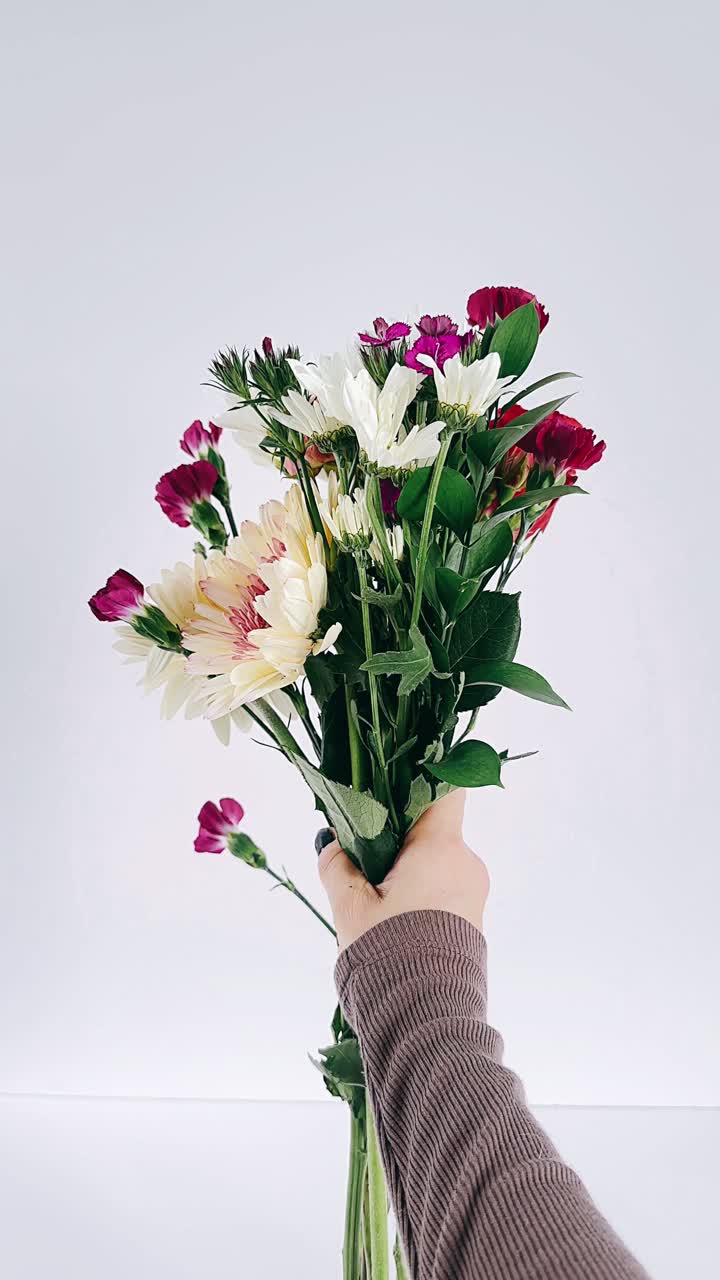Tenendo in mano un bouquet di fiori